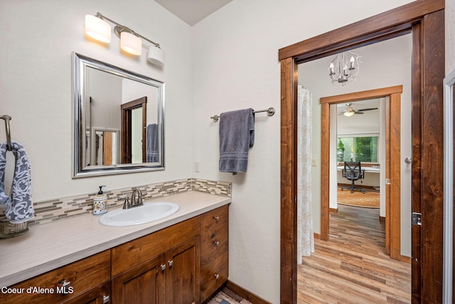 1044 E Maroon Creek Dr, Hayden, ID 83835 - bathroom featuring a chandelier, vanity, wood finished floors, baseboards, and backsplash