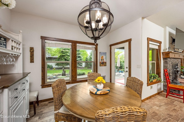 1044 E Maroon Creek Dr, Hayden, ID 83835 - dining room with baseboards, a chandelier, and a stone fireplace