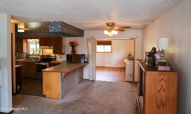 8705 N Ramsey Rd, Hayden, ID 83835 - kitchen with stainless steel range with electric cooktop, under cabinet range hood, a textured ceiling, ceiling fan, and a peninsula