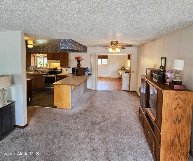 8705 N Ramsey Rd, Hayden, ID 83835 - kitchen with electric range, a textured ceiling, a peninsula, a ceiling fan, and carpet