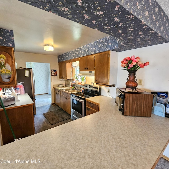 8705 N Ramsey Rd, Hayden, ID 83835 - kitchen featuring appliances with stainless steel finishes, under cabinet range hood, brown cabinetry, and light countertops