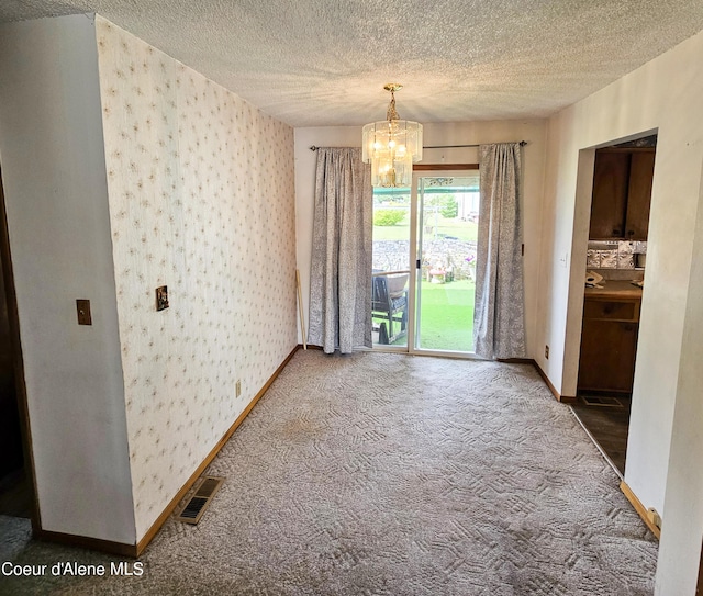8705 N Ramsey Rd, Hayden, ID 83835 - unfurnished dining area featuring wallpapered walls, a chandelier, carpet flooring, a textured ceiling, and baseboards