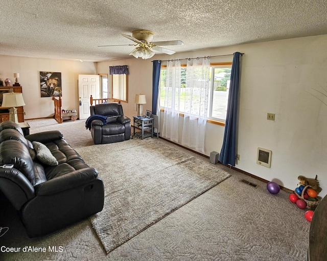 8705 N Ramsey Rd, Hayden, ID 83835 - living room with carpet floors, a ceiling fan, a textured ceiling, heating unit, and baseboards