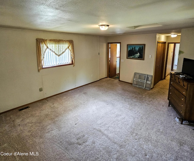 8705 N Ramsey Rd, Hayden, ID 83835 - unfurnished living room featuring carpet floors, a textured ceiling, and baseboards