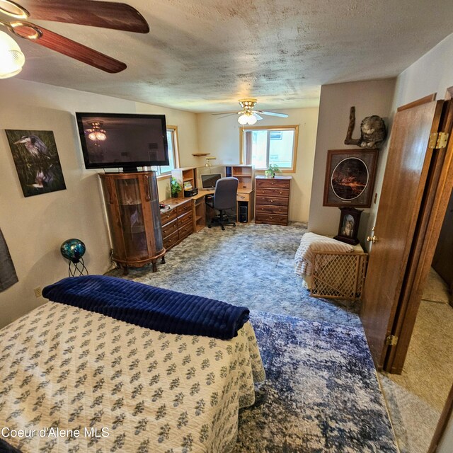 8705 N Ramsey Rd, Hayden, ID 83835 - carpeted bedroom featuring a desk, a textured ceiling, and a ceiling fan