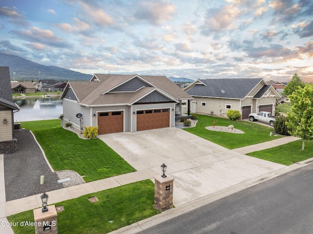 14441 N Pristine Cir, Rathdrum, ID 83858 - view of front of property featuring a front lawn, a water view, board and batten siding, concrete driveway, and a shingled roof