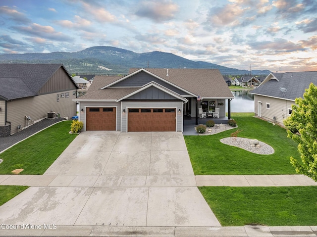 14441 N Pristine Cir, Rathdrum, ID 83858 - view of front of house with board and batten siding, a porch, a front yard, and a garage