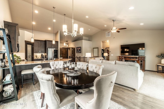 14441 N Pristine Cir, Rathdrum, ID 83858 - dining area with a ceiling fan, light wood finished floors, recessed lighting, high vaulted ceiling, and a chandelier