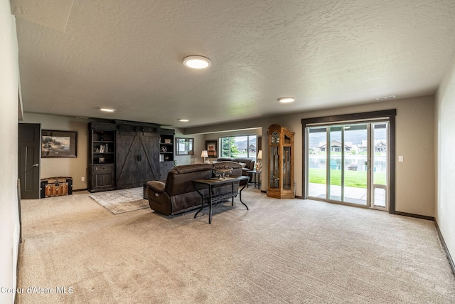14441 N Pristine Cir, Rathdrum, ID 83858 - living room with light colored carpet, a barn door, a textured ceiling, baseboards, and recessed lighting