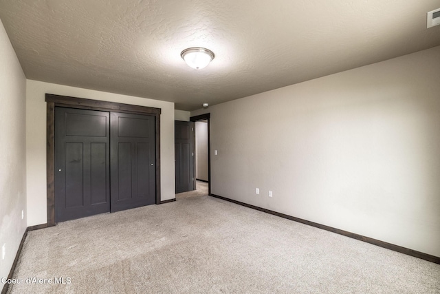 14441 N Pristine Cir, Rathdrum, ID 83858 - unfurnished bedroom with light carpet, baseboards, a closet, and a textured ceiling