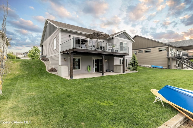 14441 N Pristine Cir, Rathdrum, ID 83858 - back of property featuring a patio area, a yard, a wooden deck, a shingled roof, and board and batten siding