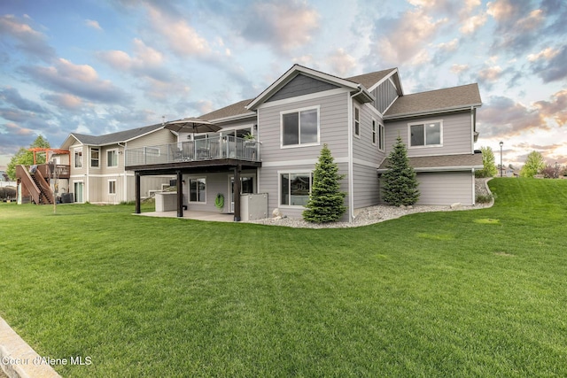 14441 N Pristine Cir, Rathdrum, ID 83858 - back of house featuring a deck, a patio, a lawn, roof with shingles, and stairs