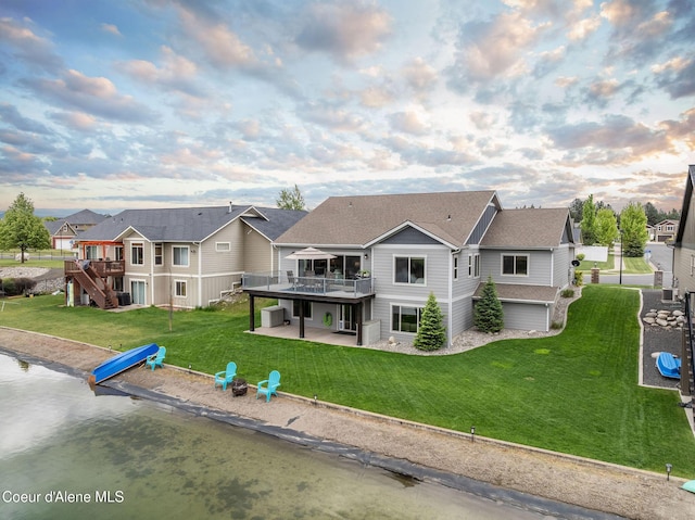 14441 N Pristine Cir, Rathdrum, ID 83858 - back of property at dusk with a patio area, a deck, a lawn, and stairs