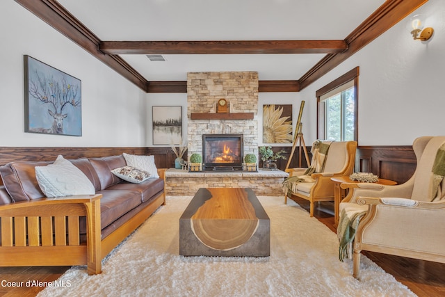 4618 S Scenic Dr, Coeur Dalene, ID 83814 - living room featuring beam ceiling, wood finished floors, a stone fireplace, ornamental molding, and a wainscoted wall