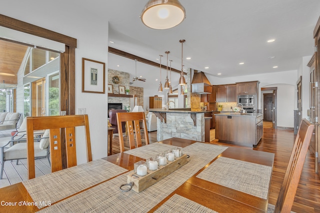 4618 S Scenic Dr, Coeur Dalene, ID 83814 - dining area with wood finished floors, a fireplace, arched walkways, recessed lighting, and ceiling fan