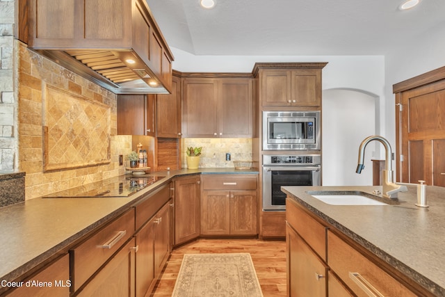 4618 S Scenic Dr, Coeur Dalene, ID 83814 - kitchen with stainless steel appliances, a sink, light wood-style floors, dark countertops, and decorative backsplash
