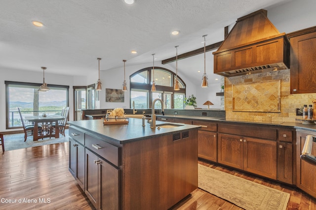 4618 S Scenic Dr, Coeur Dalene, ID 83814 - kitchen featuring a sink, dark countertops, custom range hood, lofted ceiling, and plenty of natural light