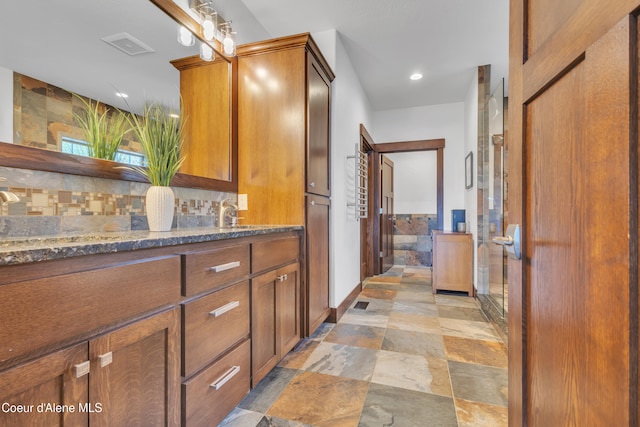 4618 S Scenic Dr, Coeur Dalene, ID 83814 - full bath with double vanity, stone tile flooring, decorative backsplash, recessed lighting, and baseboards