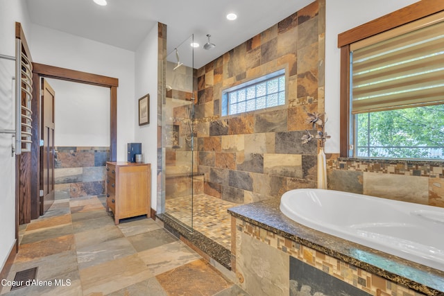 4618 S Scenic Dr, Coeur Dalene, ID 83814 - bathroom with a tile shower, a garden tub, healthy amount of natural light, stone tile floors, and tile walls