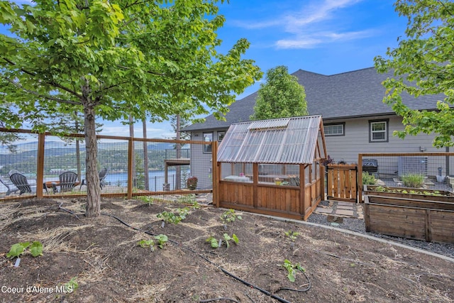 4618 S Scenic Dr, Coeur Dalene, ID 83814 - rear view of property featuring an exterior structure, a shingled roof, an outdoor structure, and a vegetable garden