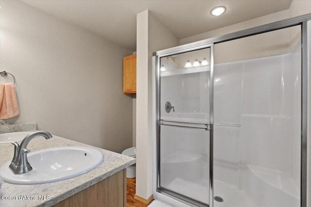 23815 N Rapalla Ct, Athol, ID 83801 - bathroom featuring a stall shower, vanity, toilet, and wood finished floors
