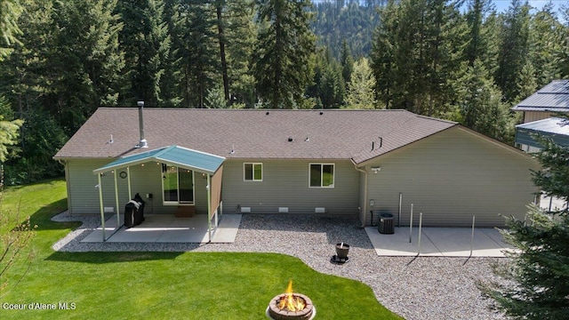 23815 N Rapalla Ct, Athol, ID 83801 - back of house with an outdoor fire pit, a patio, a lawn, central AC unit, and a view of trees