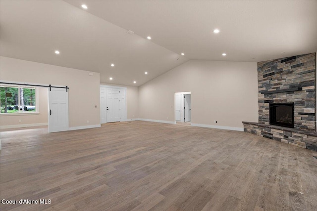 10233 Bunco Rd, Athol, ID 83801 - unfurnished living room featuring recessed lighting, lofted ceiling, a fireplace, light wood-type flooring, and baseboards