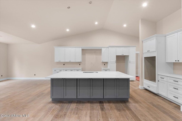 10233 Bunco Rd, Athol, ID 83801 - kitchen with a large island, gray cabinets, vaulted ceiling, white cabinets, and light wood-type flooring