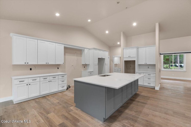 10233 Bunco Rd, Athol, ID 83801 - kitchen featuring white cabinets, vaulted ceiling, light wood-type flooring, gray cabinetry, and a spacious island