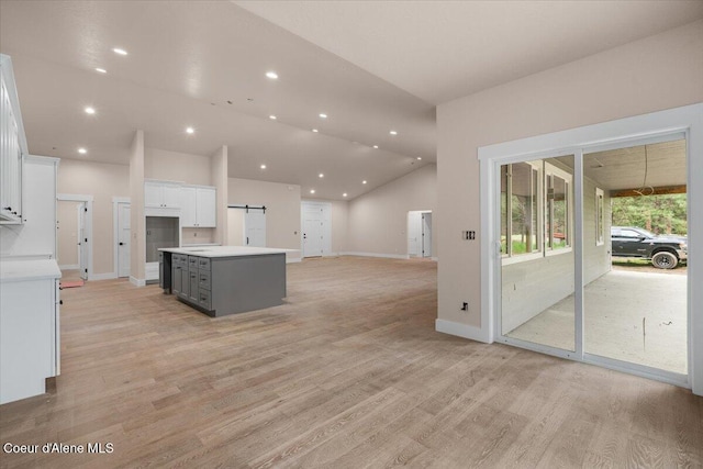 10233 Bunco Rd, Athol, ID 83801 - kitchen with white cabinetry, a kitchen island, gray cabinetry, a barn door, and baseboards