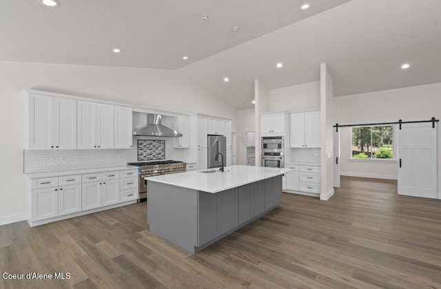 10233 Bunco Rd, Athol, ID 83801 - kitchen with white cabinets, an island with sink, light countertops, premium appliances, and wall chimney range hood