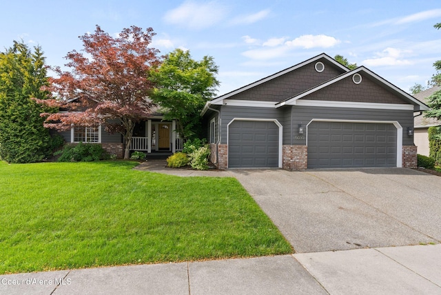5030 E Frazier Dr, Post Falls, ID 83854 - view of front of house with a garage, a front lawn, brick siding, driveway, and a porch