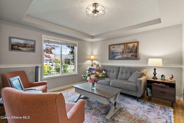 5030 E Frazier Dr, Post Falls, ID 83854 - living area featuring a tray ceiling, wood finished floors, and baseboards