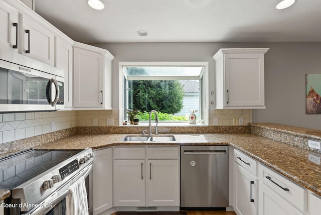 5030 E Frazier Dr, Post Falls, ID 83854 - kitchen featuring appliances with stainless steel finishes, a sink, white cabinetry, tasteful backsplash, and recessed lighting