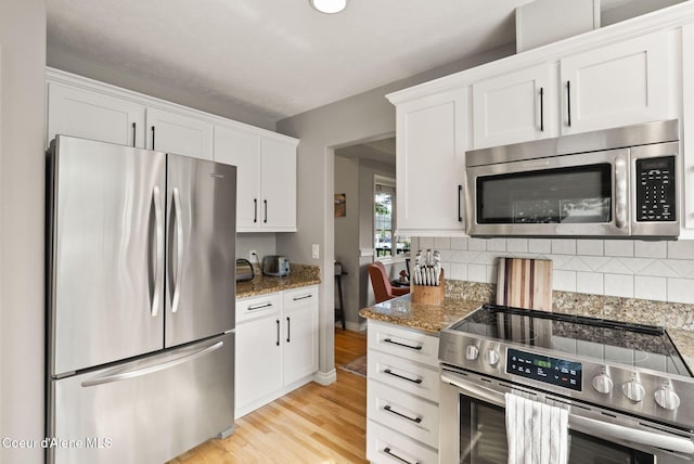 5030 E Frazier Dr, Post Falls, ID 83854 - kitchen featuring stainless steel appliances, tasteful backsplash, white cabinetry, light stone countertops, and light wood-style flooring
