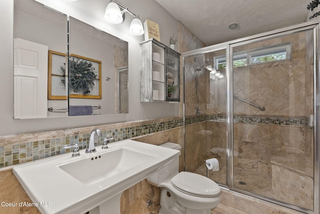5030 E Frazier Dr, Post Falls, ID 83854 - bathroom with toilet, tile walls, and a shower stall