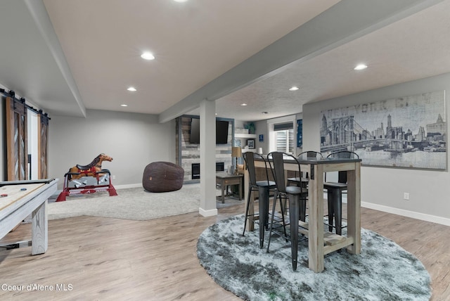 5030 E Frazier Dr, Post Falls, ID 83854 - playroom with baseboards, a barn door, recessed lighting, light wood-style flooring, and a fireplace
