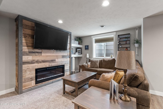 5030 E Frazier Dr, Post Falls, ID 83854 - living room featuring a glass covered fireplace, baseboards, a textured ceiling, and recessed lighting