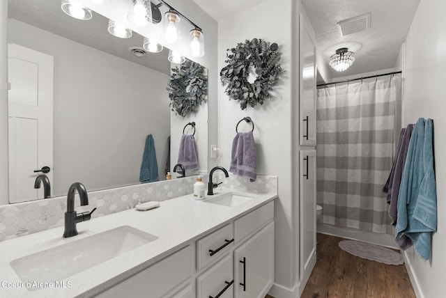 5030 E Frazier Dr, Post Falls, ID 83854 - full bathroom featuring double vanity, wood finished floors, toilet, baseboards, and a shower with curtain
