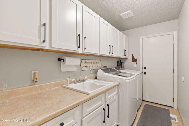 5030 E Frazier Dr, Post Falls, ID 83854 - laundry room featuring cabinet space, washing machine and dryer, and a textured ceiling