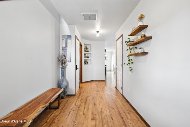 12404 W Devonshire Ave, Post Falls, ID 83854 - hall with light wood-type flooring, built in shelves, and baseboards