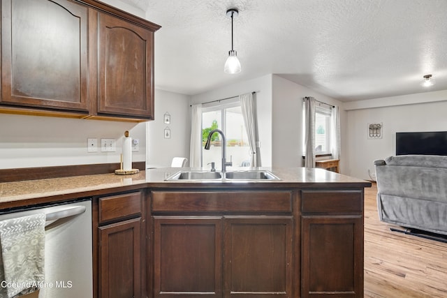 12404 W Devonshire Ave, Post Falls, ID 83854 - kitchen featuring dishwasher, a sink, open floor plan, light wood-type flooring, and a peninsula