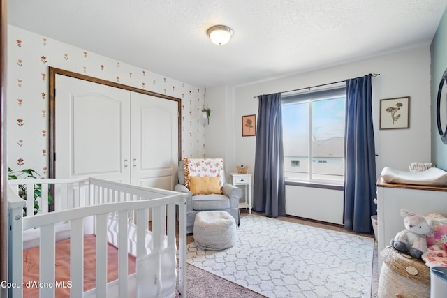 12404 W Devonshire Ave, Post Falls, ID 83854 - bedroom featuring wallpapered walls, a closet, and a crib