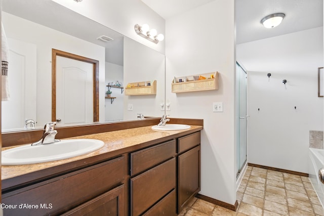 12404 W Devonshire Ave, Post Falls, ID 83854 - full bath with double vanity, baseboards, a garden tub, stone finish floors, and a stall shower