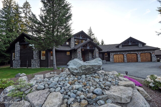 225 Fairway Dr, Priest Lake, ID 83856 - craftsman house featuring stone siding, an attached garage, and asphalt driveway
