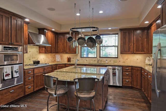 225 Fairway Dr, Priest Lake, ID 83856 - kitchen featuring wall chimney range hood, appliances with stainless steel finishes, a sink, dark wood-style floors, and recessed lighting