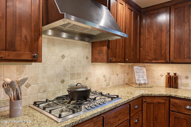 225 Fairway Dr, Priest Lake, ID 83856 - kitchen with wall chimney exhaust hood, stainless steel gas stovetop, backsplash, and light stone counters