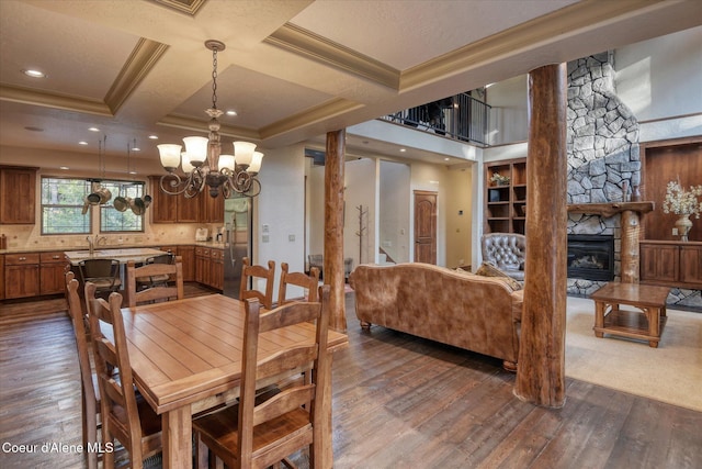 225 Fairway Dr, Priest Lake, ID 83856 - dining area featuring dark wood finished floors, a chandelier, crown molding, a fireplace, and coffered ceiling
