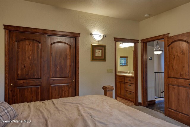 225 Fairway Dr, Priest Lake, ID 83856 - carpeted bedroom with a sink, ensuite bath, and a textured wall