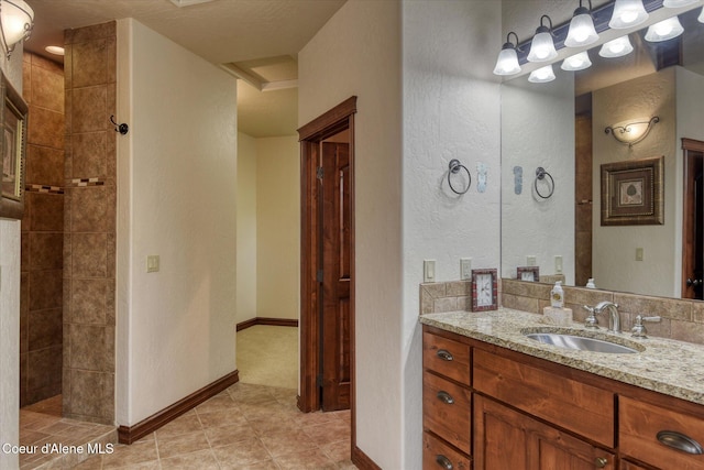 225 Fairway Dr, Priest Lake, ID 83856 - bathroom featuring vanity, a textured wall, a tile shower, tile patterned flooring, and baseboards